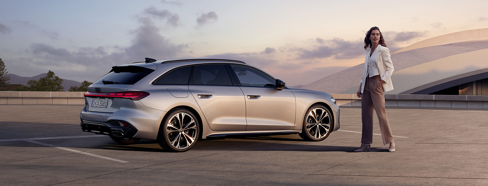 Nya Audi A5 Avant står parkerad, en business-klädd kvinna är på väg till bilen