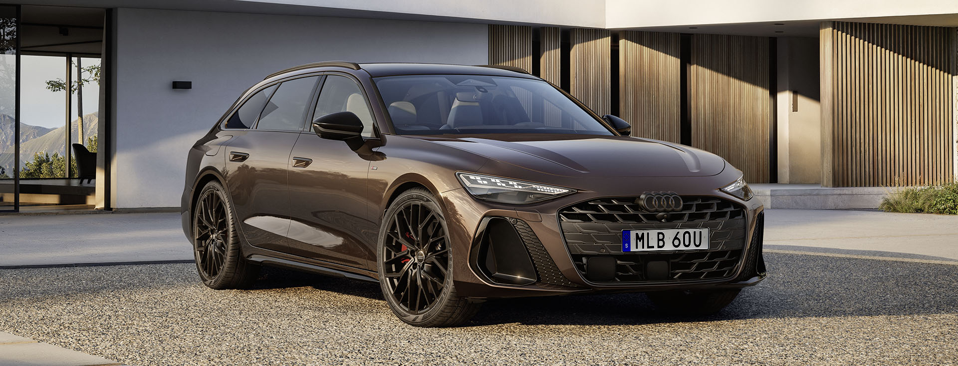 Nya Audi A6 Avant i snygg brun-metallic färg står parkerad framför ett hus nyggt i modern stil
